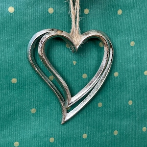 Elegante par de adornos colgantes de corazón de metal plateado para árbol de Navidad, de 12 y 10 cm, con cuerda de yute.