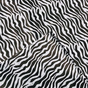 Puede incluir: Tela de estampado de cebra en blanco y negro con una superficie texturizada.