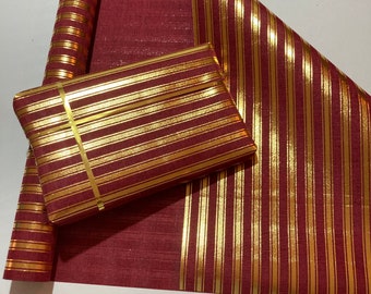 May include: A roll of red and gold striped wrapping paper. The paper has a metallic sheen and is perfect for wrapping gifts.