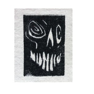 May include: Black and white abstract print of a face with a large, swirling eye and a wide, toothy grin. The print is on a white canvas.