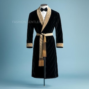 May include: A black velvet robe with a quilted beige lining and a gold tassel. The robe has a shawl collar and a sash.