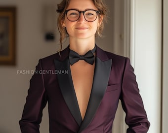 May include: A person wearing a burgundy tuxedo jacket with a black satin lapel and bow tie. The person is wearing glasses and has a neutral expression.