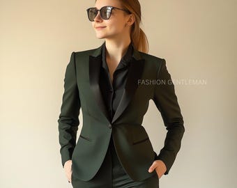 Op de afbeelding: Een donkergroen pak met een zwarte satijnen revers en bies. Het pak bestaat uit een blazer en een bijpassende broek. De tekst "FASHION GENTLEMAN" is zichtbaar aan de rechterkant van de afbeelding. De persoon draagt een zonnebril.