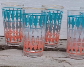May include: Set of six vintage highball glasses. Each glass features a teal and coral diamond pattern with gold rims. The glasses are clear and appear to be made of glass.