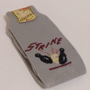 May include: Gray socks with a red and white bowling pin graphic and the word "STRIKE" in red. The socks have a tag that says "Yogi" and "Stretch" with a cartoon dog.
