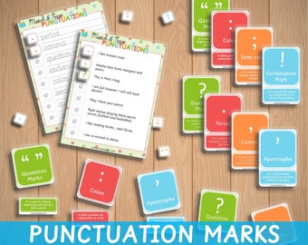 May include: A set of colorful flashcards with punctuation marks and their definitions. The cards are laid out on a wooden surface. The cards include punctuation marks such as a period, comma, question mark, exclamation mark, colon, semicolon, apostrophe, and quotation marks.