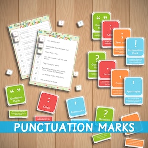 Peut inclure: Un jeu de cartes mémoire colorées avec des signes de ponctuation et leurs définitions. Les cartes sont disposées sur une surface en bois. Les cartes comprennent des signes de ponctuation tels qu'un point, une virgule, un point d'interrogation, un point d'exclamation, un deux-points, un point-virgule, une apostrophe et des guillemets.