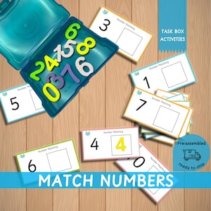May include: A set of colorful number matching cards with a blue plastic container filled with foam number tiles. The cards have the words "Number Matching" and a number on each card. The container has the words "TASK BOX ACTIVITIES" on the side. The text "MATCH NUMBERS" is at the bottom of the image.