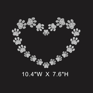 May include: A heart shape made of white paw prints on a black background. The design is 26.4 cm wide by 19.3 cm high. The paw prints are formed from small white dots, giving a textured look. The theme is related to pets and animals.