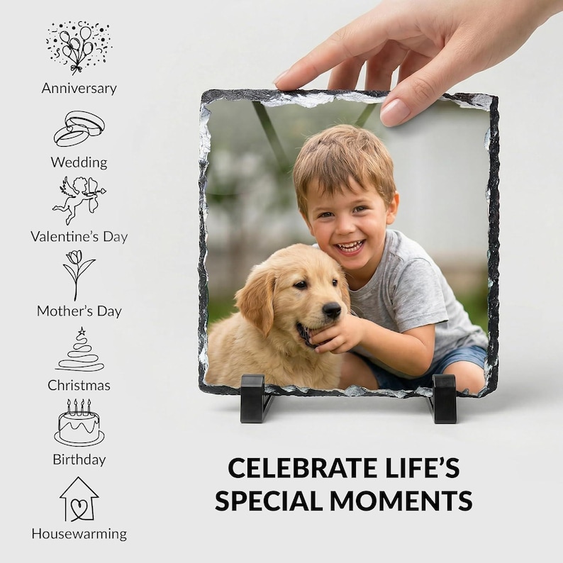 May include: A square slate photo plaque with rough, chiseled edges featuring a color photograph of a young child and a golden retriever puppy. The plaque is displayed on two black plastic stands and includes text reading CELEBRATE LIFE'S SPECIAL MOMENTS.