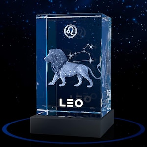 May include: A rectangular clear glass block featuring a laser-etched 3D geometric lion figure and the Leo zodiac constellation. The top displays the Leo symbol, and the word LEO is printed in white at the bottom. It rests on a black base.