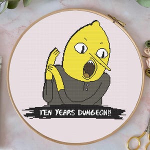 Puede incluir: Patrón de punto de cruz con un personaje de dibujos animados amarillo con una nariz grande y una expresión de sorpresa. El personaje lleva una camisa gris oscuro y el texto "TEN YEARS DUNGEON!" está debajo del personaje.