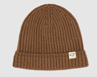May include: A brown ribbed knit beanie with a small, white patch featuring a black wolf silhouette.