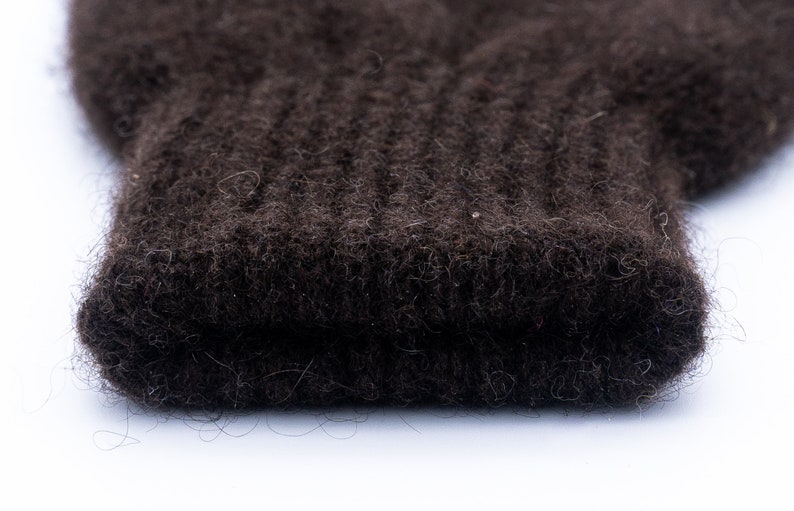 May include: Close-up of a dark brown knitted fabric with a fuzzy texture.