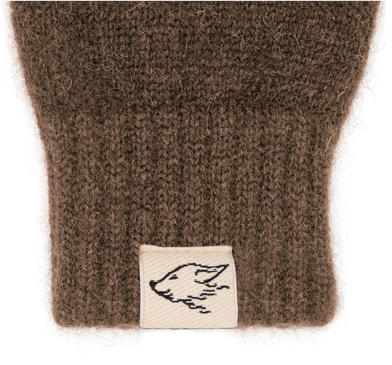 May include: Brown knitted gloves with a small white label featuring a black fox design.