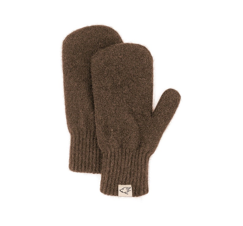May include: A pair of brown knitted mittens with a small brown label on the cuff. The label has a white bird design.