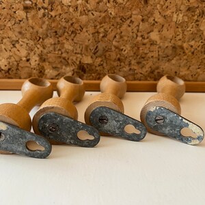 K&ouml;nnte beinhalten: Vier Holz-Vorhangstangenhalter mit schraubbaren Metallkappen. Jeder Halter hat ein Loch f&uuml;r eine Schraube und eine Metallschlaufe zum Aufh&auml;ngen einer Vorhangstange.