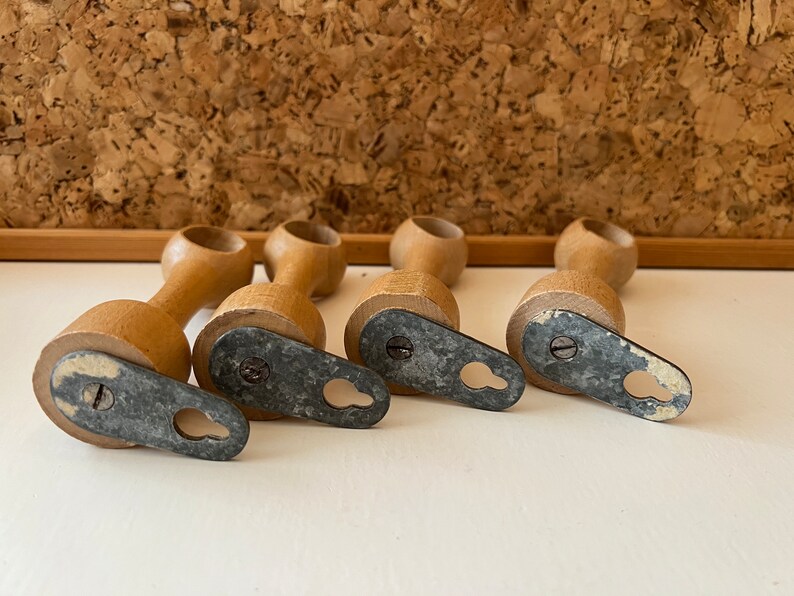 K&ouml;nnte beinhalten: Vier Holz-Vorhangstangenhalter mit schraubbaren Metallkappen. Jeder Halter hat ein Loch f&uuml;r eine Schraube und eine Metallschlaufe zum Aufh&auml;ngen einer Vorhangstange.