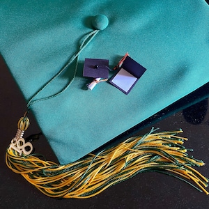Birrete y diploma de graduación en miniatura