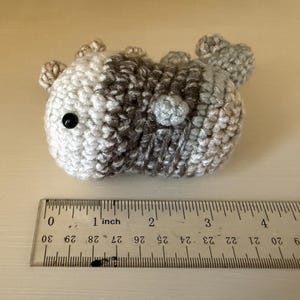 以下が含まれることがあります： 黒い持ち手と「But First, Coffee」の太字の黒い文字が入った白いセラミックマグ。白い表面に置かれています。マグカップの高さは約10cmです。