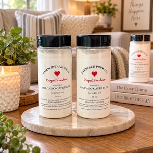 Puede incluir: Dos botellas de plástico transparente con tapas negras que contienen polvo ambientador para alfombras. Las etiquetas dicen Pampered Princess Carpet Freshener, Volcano Capri Blue, Sprinkle me, 16 oz, con instrucciones e ingredientes.