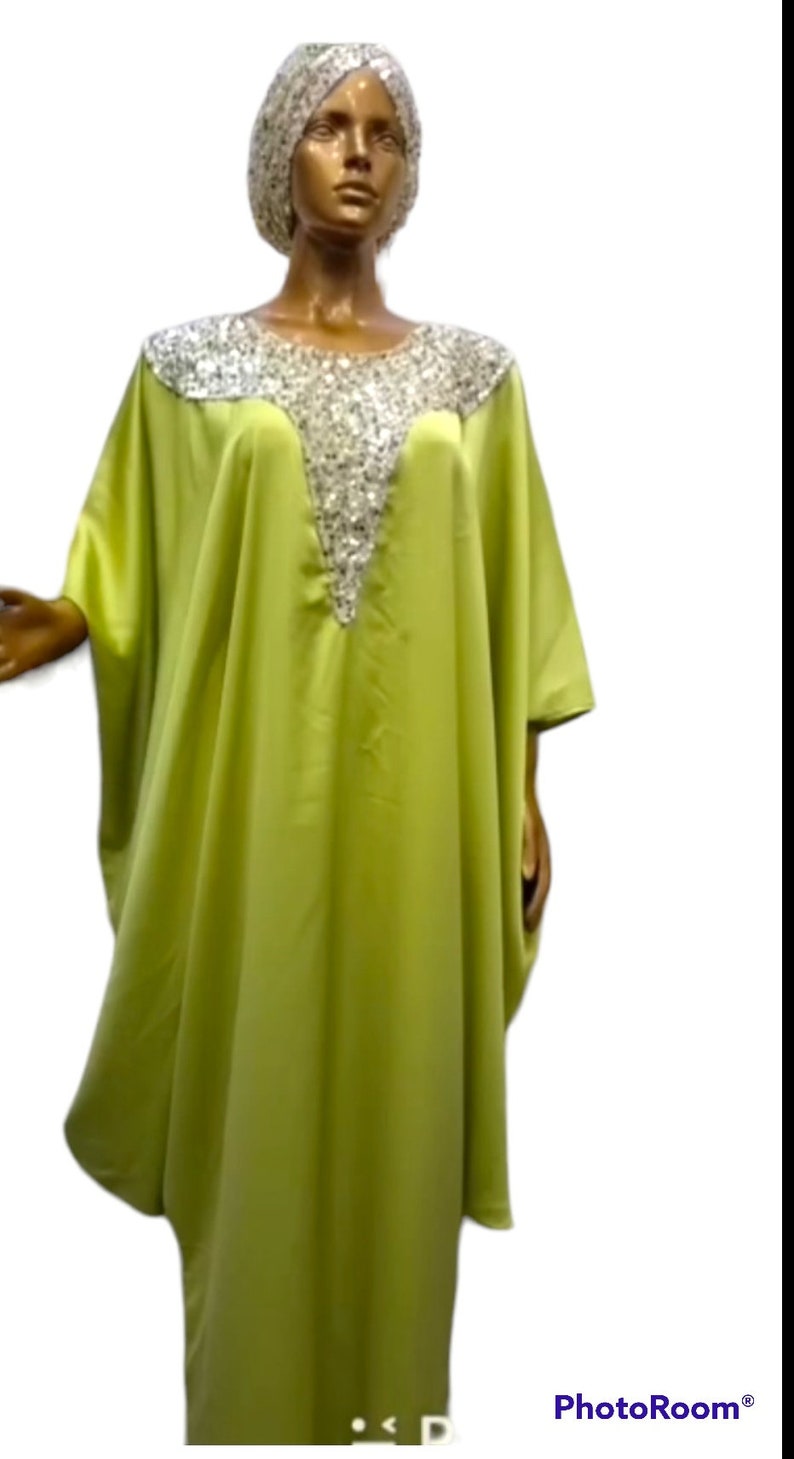 Puede incluir: Una kaftan verde lima con un escote de lentejuelas plateadas. La kaftan tiene un corte holgado y fluido, ideal para un look casual y veraniego.