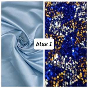 Puede incluir: Dos muestras de tela, una es una tela de sat&eacute;n azul claro, la otra es una tela de lentejuelas azul, dorada y plateada. El texto "blue 1" est&aacute; impreso en la imagen.