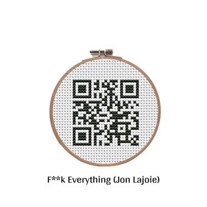 May include: A cross-stitch embroidery hoop featuring a black and white QR code design. The text "F**k Everything (Jon Lajoie)" is displayed below the hoop. The hoop is made of wood and the fabric is white.