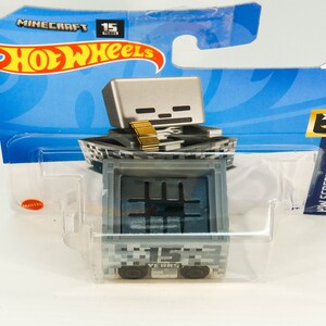 Puede incluir: Un coche de juguete Hot Wheels Minecraft Skeleton gris y negro con una espada dorada. El coche est&aacute; en un paquete de pl&aacute;stico con el logotipo de Hot Wheels y el logotipo de Minecraft. El paquete tambi&eacute;n dice "15 a&ntilde;os".