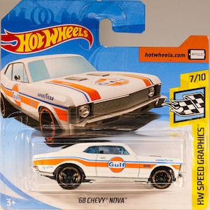 May include: White die-cast toy car model of a 1968 Chevrolet Nova with Gulf racing livery. The car has orange and blue accents and the words "GOOD YEAR" and "SS" on the sides. The car is on a blue background with the words "Hot Wheels" and "HW SPEED GRAPHICS" on the packaging.