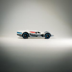 Könnte beinhalten: Ein weißes und graues Spielzeugauto mit blauen und roten Akzenten. Das Auto hat schwarze Räder mit blauen Felgen und ein Star Wars-Logo. Ein Sammlerstück.