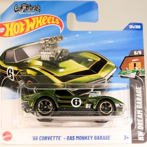 May include: Green 1968 Corvette toy car with a large engine sticking out of the bonnet. The car has a black stripe and the number 6 on the side. The car is part of the Hot Wheels Gas Monkey Garage series. The packaging shows the car is number 134 out of 250.