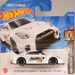 Könnte beinhalten: Weißes Hot Wheels LB-Silhouette Works GT Nissan 35GT-RR Ver.2 Druckgussauto. Das Auto hat schwarze Räder und einen Heckspoiler. Die Verpackung enthält den Text "LIBERTY WALK" und "HW DREAM GARAGE".