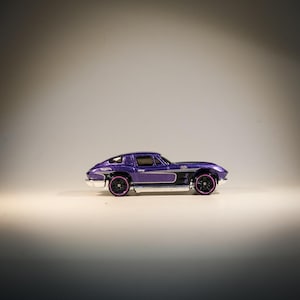 May include: A purple die-cast toy car model of a Chevrolet Corvette.