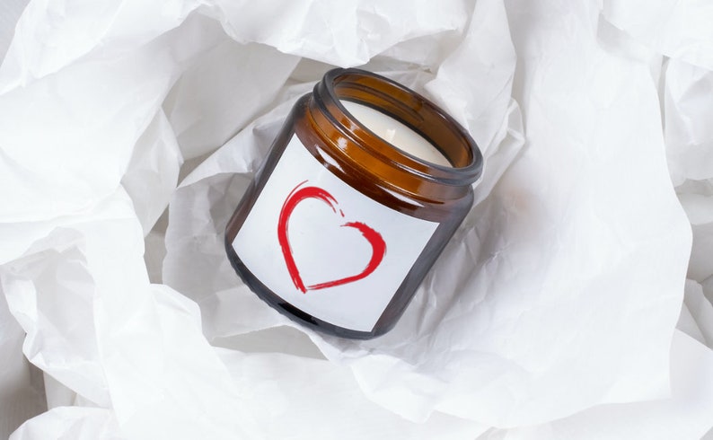 May include: A brown glass candle jar with a white label and a red heart design. The label says "Love".