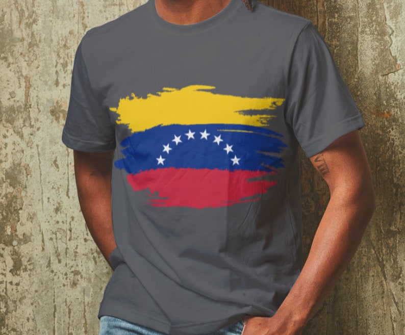 May include: A dark gray t-shirt with a yellow, blue, and red paint-splattered design of the Venezuelan flag.