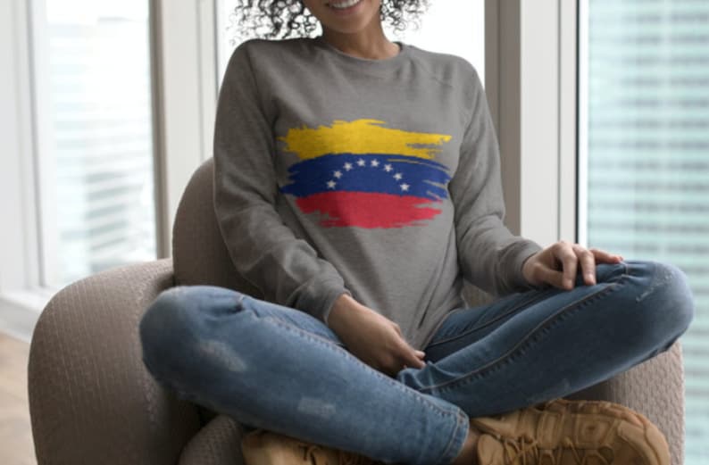 May include: A gray sweatshirt with a yellow, blue, and red paint-splattered design of the Venezuelan flag.