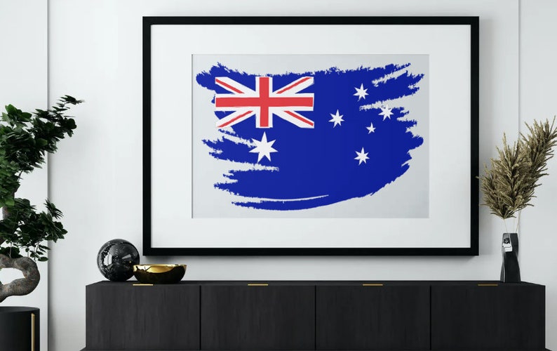 May include: A framed print of the Australian flag with a white background and a blue and red flag design. The flag is painted in a brushstroke style.