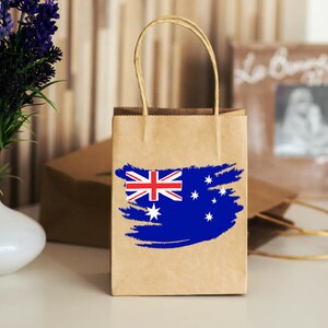 May include: A brown paper shopping bag with a blue and white Australian flag design. The bag has a white handle.