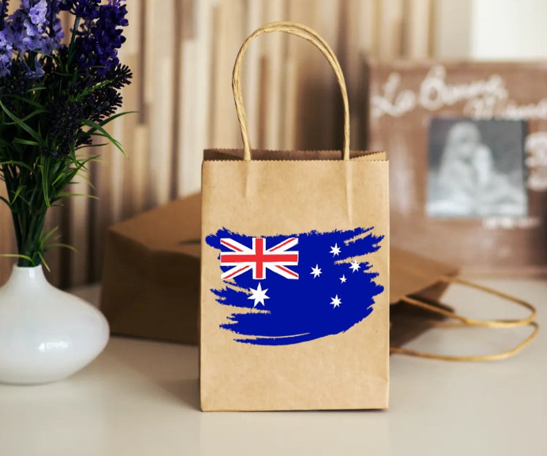 May include: A brown paper shopping bag with a blue and white Australian flag design. The bag has a white handle.