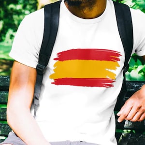 May include: A white t-shirt with a red and yellow brushstroke design resembling the Spanish flag.
