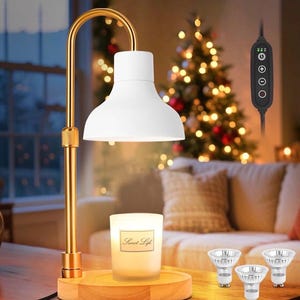 May include: A white candle warmer lamp with a gold-colored arched arm and a wooden base. The lamp has a white shade and a control panel on the cord. A lit candle in a glass jar with the text "Sweet Life" is on the wooden base. Three light bulbs are also visible.