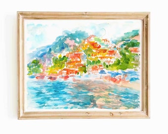 Peut inclure: Une peinture à l'aquarelle d'une ville côtière avec des bâtiments colorés sur une colline surplombant une étendue d'eau bleue. La peinture est encadrée dans un cadre en bois clair.