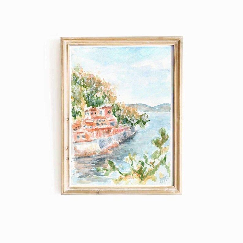 May include: Watercolor painting of a red building on a cliff overlooking a blue body of water. The building is surrounded by green trees and bushes. The water is calm and reflects the sky.