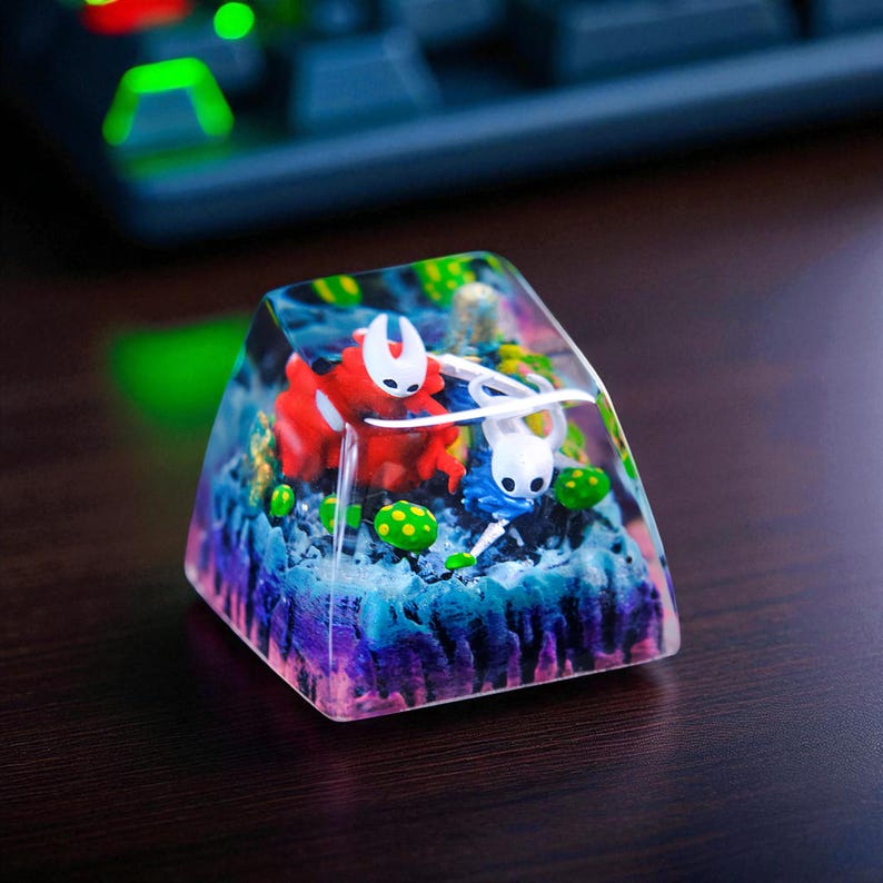 May include: A custom keycap featuring a red and white character and a blue and white character set against a colorful, layered background. The keycap is encased in clear resin, with green and yellow accents.