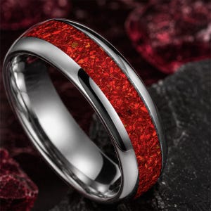 Close up of the vibrant crushed ruby gemstone inlay on a polished tungsten wedding ring.