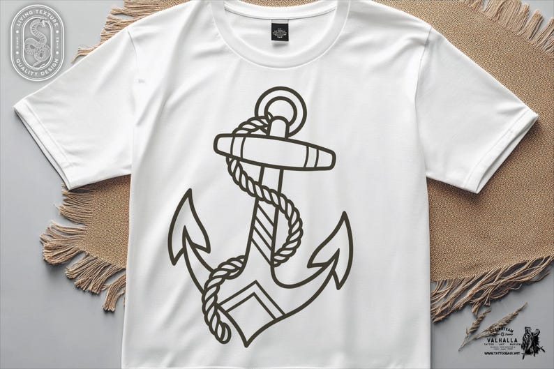May include: White t-shirt featuring a black anchor design with rope detailing. The anchor graphic is centered on the shirt. The shirt has short sleeves and a crew neck. The design is a nautical theme.