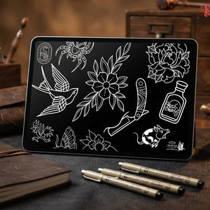 May include: A digital tablet displays a collection of white line art tattoo designs on a black background. The designs include a swallow, flowers, a knife, and a skull bottle. The tablet is surrounded by leather-bound notebooks, pens, and ink bottles.