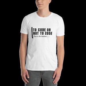 Op de afbeelding: Wit T-shirt met zwarte tekst die "To code or not to code. That is the boolean..." luidt.