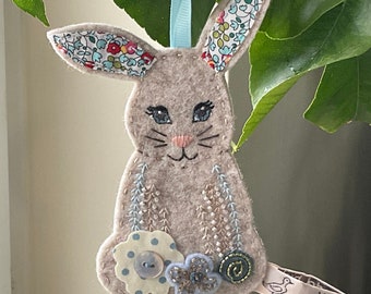 Origineel ontwerp hangend ornament paashaas gemaakt van wolvilt, handborduurwerk en kralen.